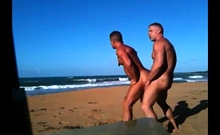 Dois machoes sarados trepando na praia nudista